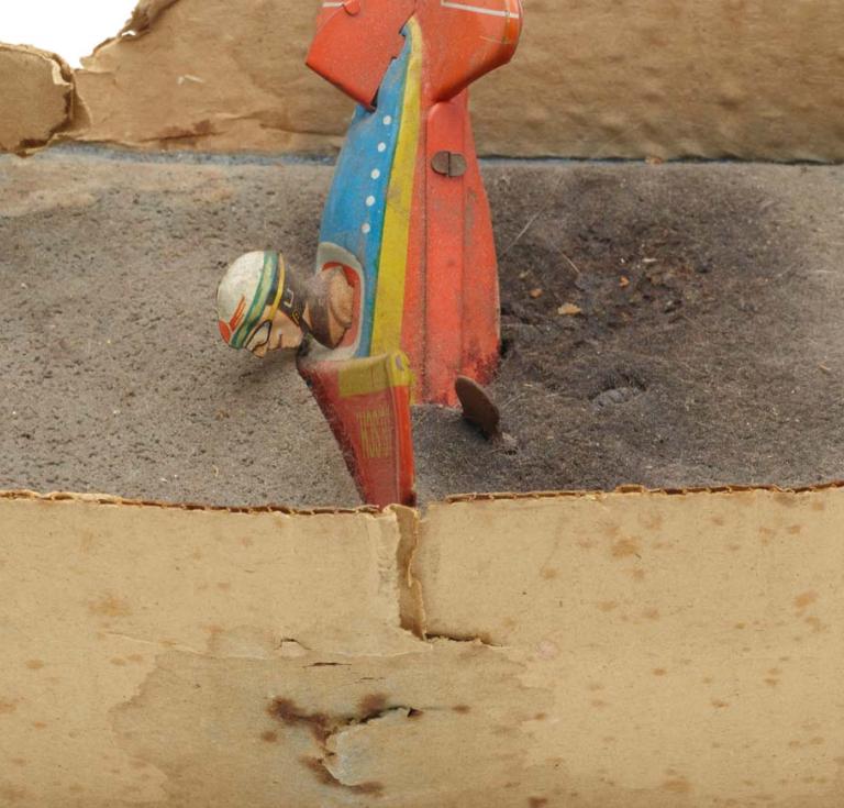Artist book of a toy airplane cast into sugar in a cardboard box