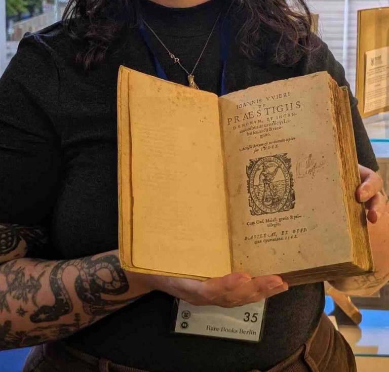 Clare Marshall of Marshall Rare Books with the expanded edition of Johann Weyer's Praestigiis Daemonum, Et Incantationibus ac ueneficiis